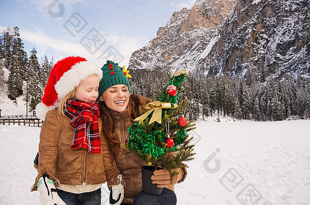 <strong>圣诞</strong>节的冬季户外活动对孩子们甚至成年人来说都是童话故事。快乐的母亲和孩子看着Christma