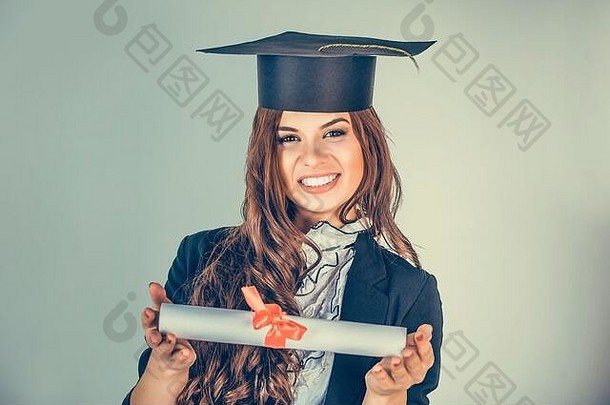 肖像特写美丽快乐的拉美裔毕业生，毕业的女学生，戴着帽子的年轻女子微笑着拿着展示文凭卷轴的绿色
