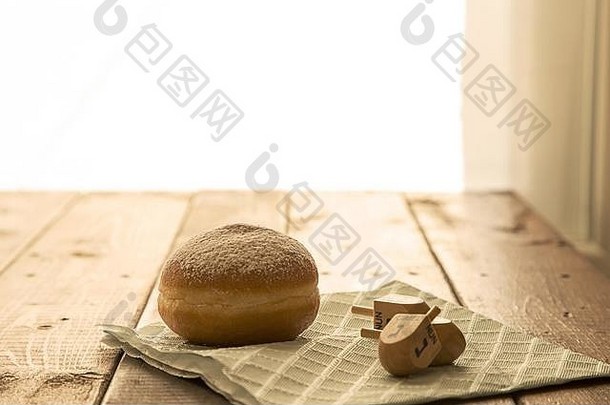 犹太教节日光明节庆祝活动的静物画概念油炸圈饼和德雷德尔放在乡村桌子上。空间，Baclight浅自由度