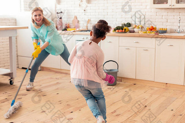 妈妈和女儿一边打扫厨房一边玩捉迷藏