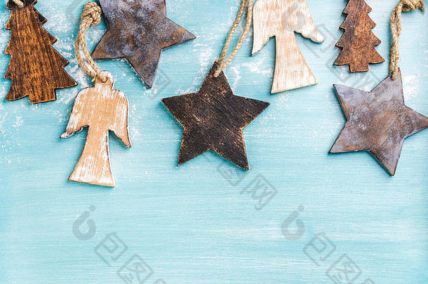 新年或圣诞节背景：木制天使、星星和小枞树覆盖在蓝色彩绘背景上，空间