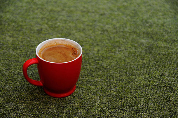 红色咖啡杯，绿色背景，装满咖啡