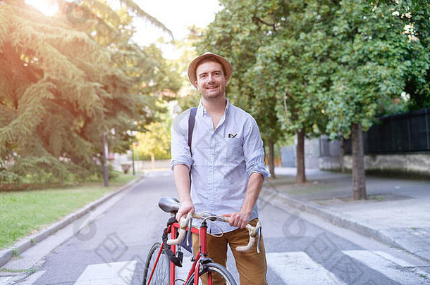 时髦男人在城市街道上骑自行车