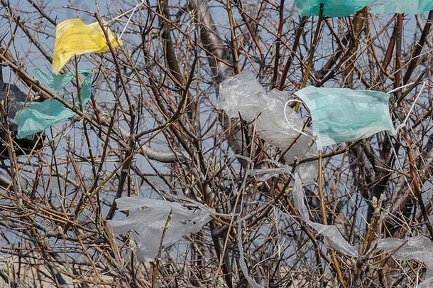 面罩和树枝上的塑料碎片。冠状病毒（新冠病毒-19）是造成污染的原因之一，因为城市公园里到处都是丢弃的口罩