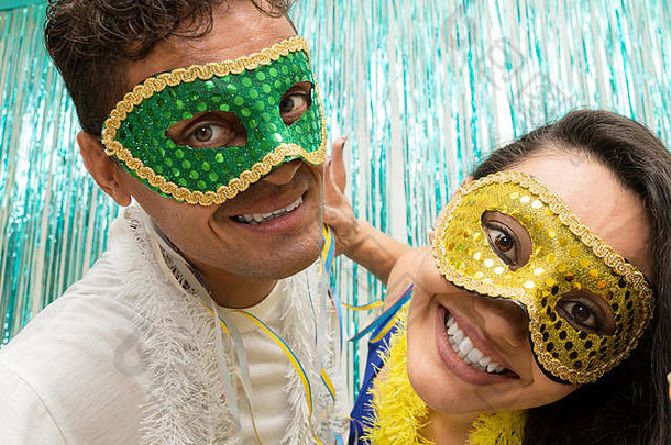 两位朋友正在为聚会合影。这对夫妇在巴西使用狂欢节面具，他们看着摄像机。