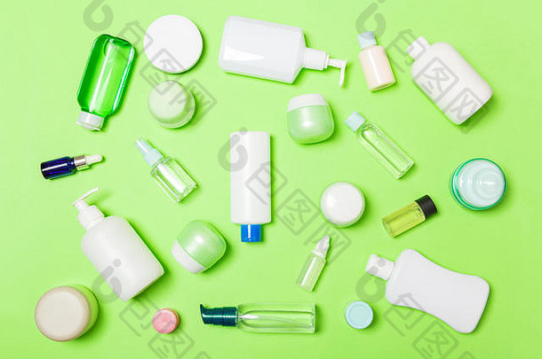 一组塑料贴身瓶平放组合，以化妆品为<strong>绿色背景</strong>，为您设计空白空间。白色化妆品套装