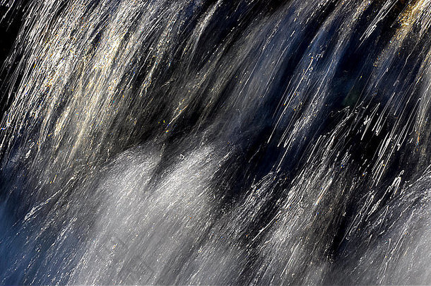 <strong>英国风景</strong>中，阳光照射在一条沼地小溪湍急水流上的抽象图像。