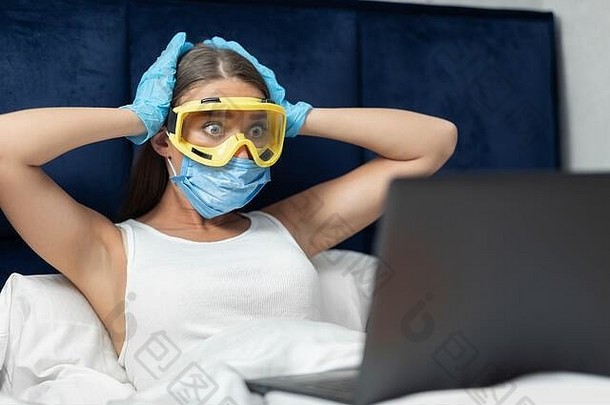 流感大流行期间，一名震惊的女孩躺在床上使用笔记本电脑