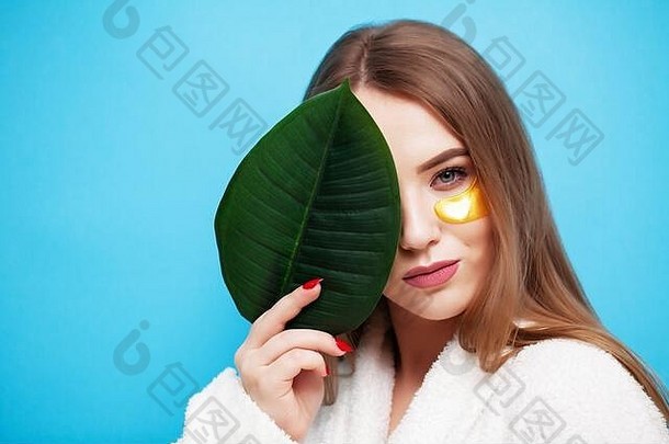 脸护理年轻的女人持有绿色叶面部皮肤健康