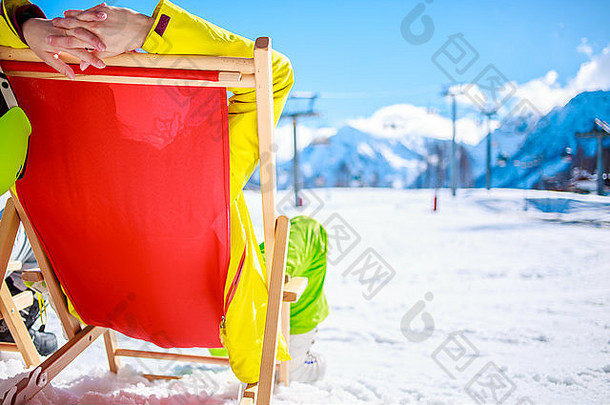 冬天在山上的女人躺在太阳躺椅上