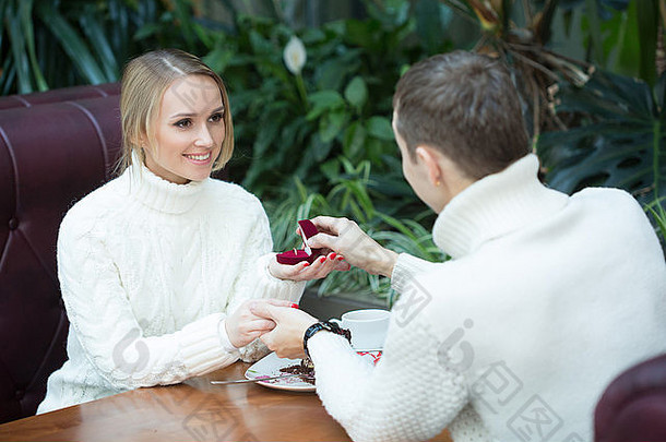 向女友求婚的年轻人提供订婚戒指。坐在咖啡馆里