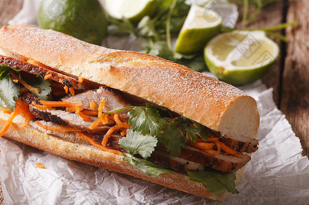 桌上有香菜和胡萝卜特写的越南三明治。水平的