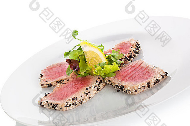 美味的金鱼牛排配上新鲜的绿色沙拉，放在白色的盘子里，背景是白色的。烹饪海鲜。
