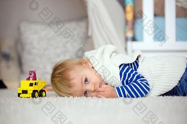 可爱的赤脚蹒跚学步的小男孩，在家里的儿童房里玩汽车玩具，孩子快乐的概念