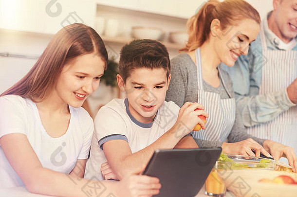 微笑的孩子们在平板电脑上看东西