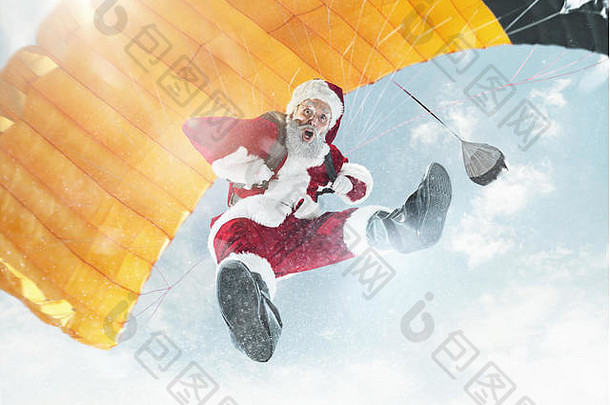 快乐圣诞节快乐假期圣诞老人老人飞行降落伞背景蓝色的天空