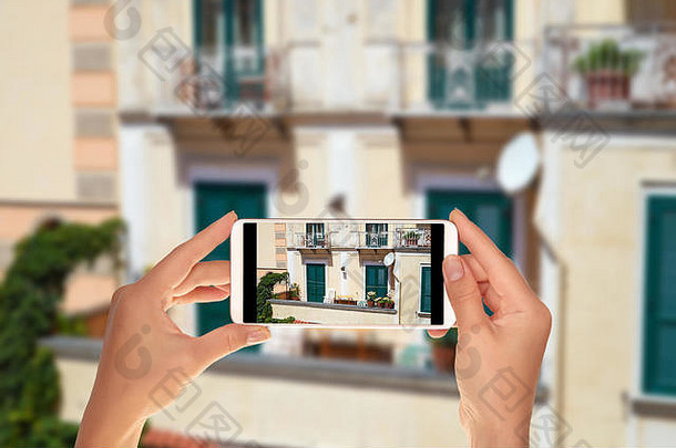 一名游客正在用手机拍摄意大利阿马尔菲典型的意大利阳台
