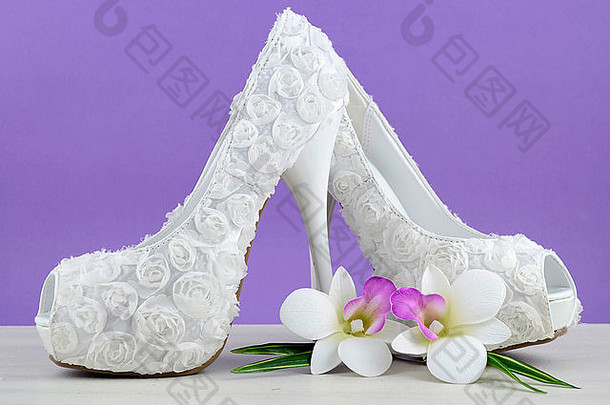 婚礼主题白色花新娘鞋子花破旧的别致的白色表格紫色的背景