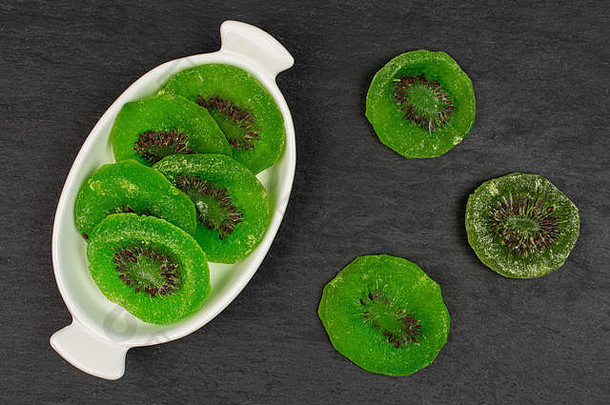 集团片甜蜜的绿色蜜饯猕猴桃白色椭圆形陶瓷碗平铺灰色石头