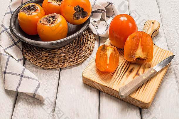 美味的橙色柿子放在木桌上