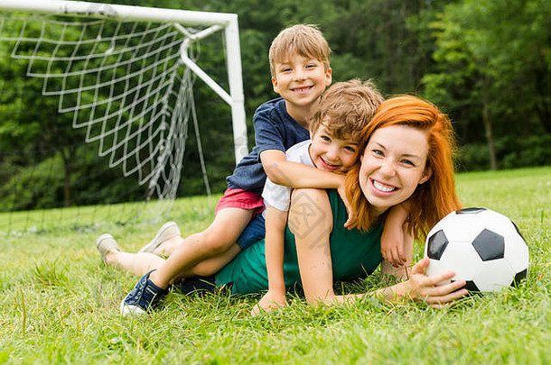 家庭、母亲和儿子在公园打球的画面