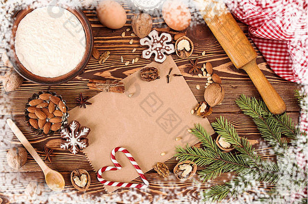准备圣诞新年糖果。木桌上的配料和节日装饰。贺卡图片。用雪和锡装饰