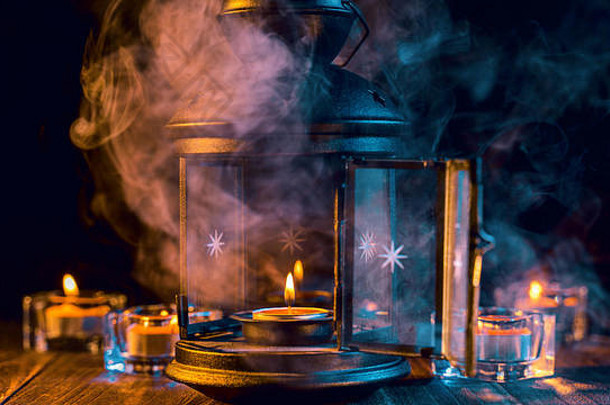 万圣节概念令人毛骨悚然的装饰照明蜡烛蜡烛持有人绿色语气烟黑暗木表格关闭