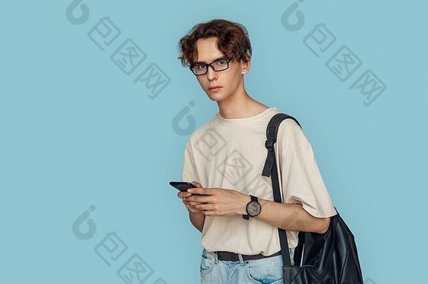 即兴说唱。戴眼镜的男人，拎着包，用智能手机上的应用程序孤立地站在灰色地带，看起来很好奇