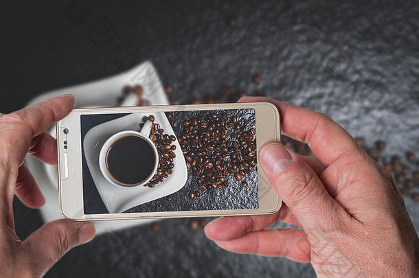 男子在黑石桌上拍摄白色咖啡杯和咖啡豆的照片