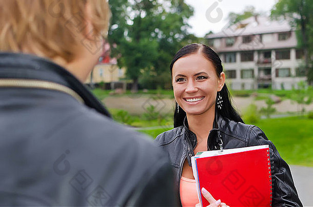 女学生在户外与朋友聊天