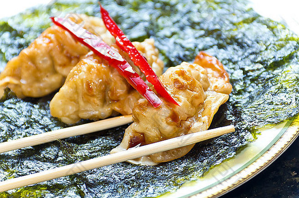 炸日本饺子脆皮烤海藻红色的胡椒装饰