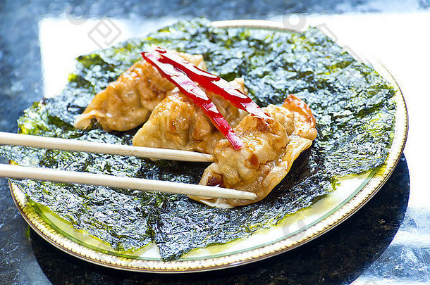 油炸日本饺子，配脆烤紫菜和红辣椒装饰