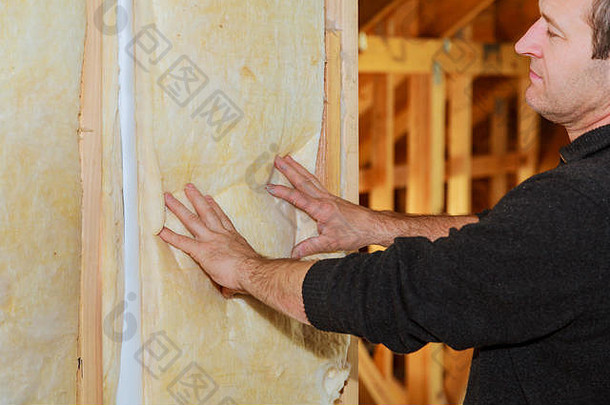 人在屋顶下铺设保温层-使用矿棉板在房屋内保温层对房屋进行保温