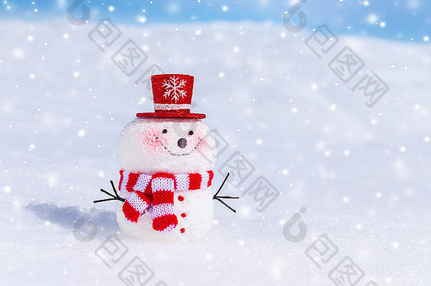 在下雪的天气里，可爱的雪人在户外，传统的冬天象征，戴着红帽子和围巾的微笑的小雪人