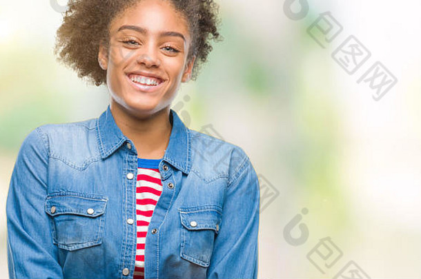 一位年轻的非裔美国妇女在与世隔绝的背景下微笑着双臂看着摄像机。积极的人。