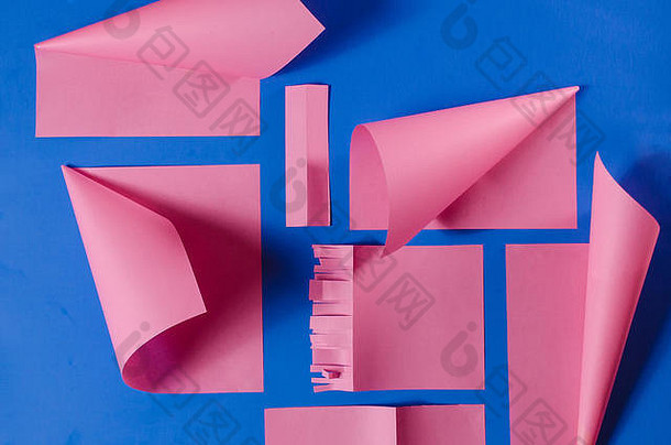 粉色剪纸在孤立的蓝色背景上，立体效果突出。