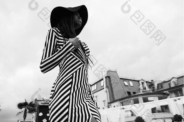 一张迷人、动人、温柔、美丽的非洲女人的黑白照片，她穿着条纹连衣裙，头戴帽子。入住vip酒<strong>店</strong>的样板房，内部<strong>装修</strong>现代。