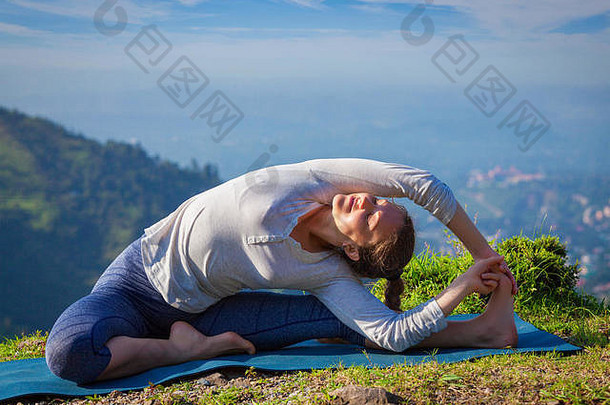 年轻的运动型修身女士做哈他瑜伽体式