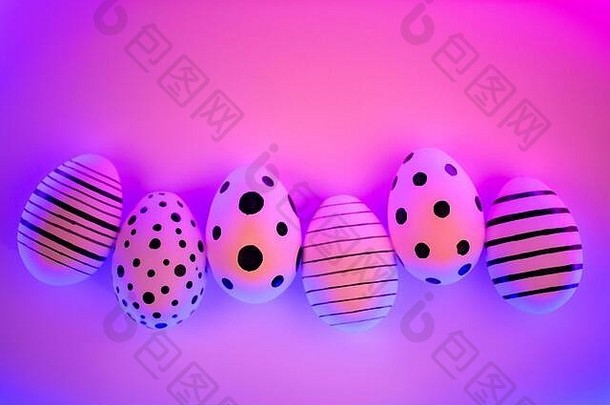 质子紫霓虹灯下的不同图形手绘鸡蛋。复活节的概念。顶视图。