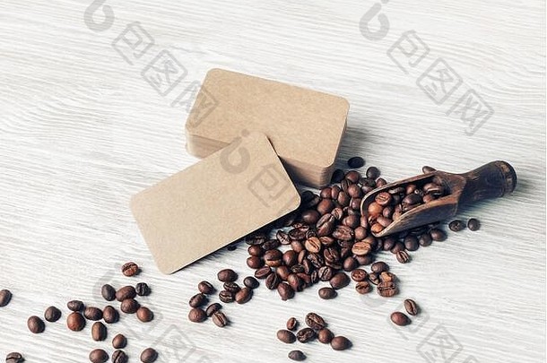 <strong>咖啡</strong>豆</strong>和牛皮纸名片置于浅色木质桌面背景上。