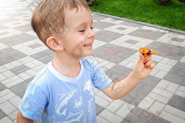 肖像快乐微笑快乐的蹒跚学步的男孩运行公园持有小玩具直升机孩子们积极的情绪笑孩子