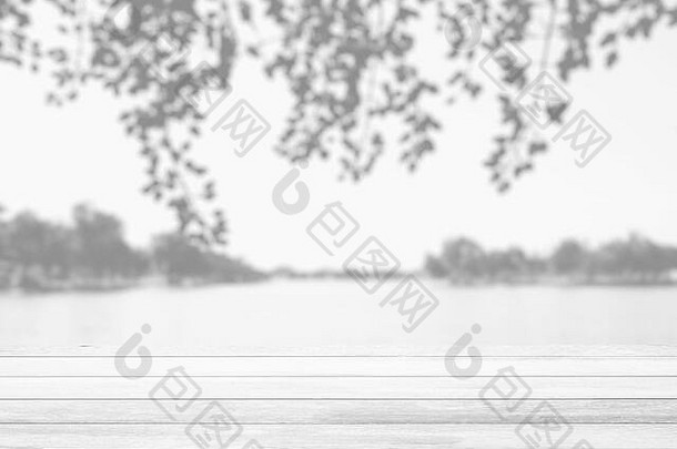 白色木桌，以秋天模糊的湖面为背景，适合产品展示和商业理念。