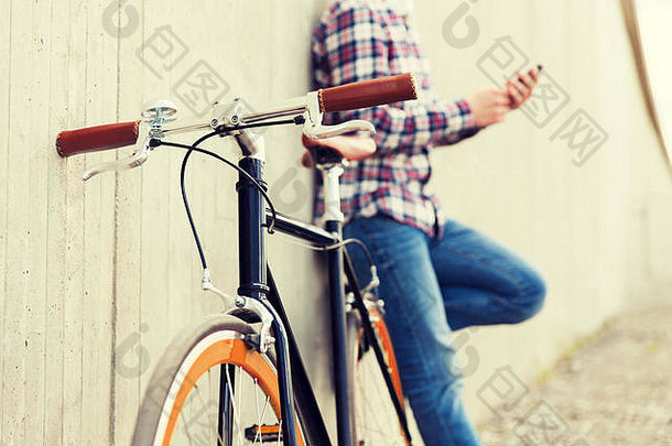 关闭赶时髦的人固定齿轮自行车男人。
