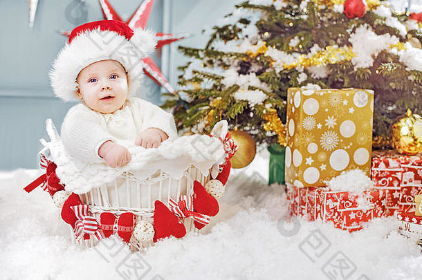 可爱的圣诞老人男孩坐着柳条篮子