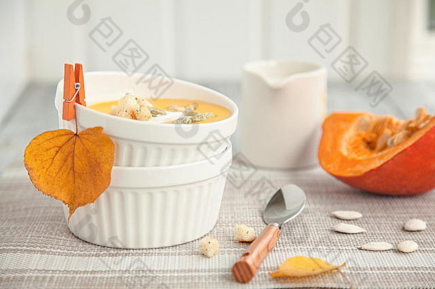 白盘子里的南瓜奶油汤和秋天的黄叶。秋季作文