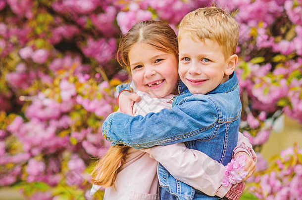 爱在空气中。浪漫的婴儿。两个孩子在樱花树花园散步。温柔的爱情。小女孩和男孩。浪漫的约会。春天是坠入爱河的时候。恋爱中的孩子粉色樱花。