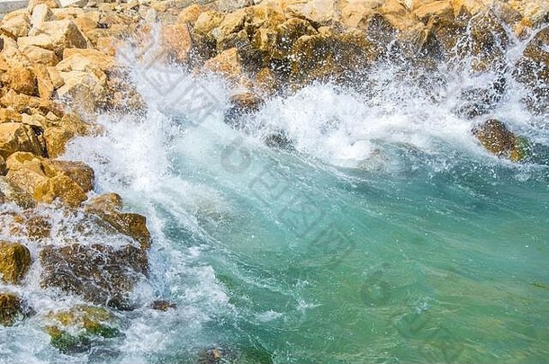 美丽的绿松石水波打悬崖白色泡沫夏天季节场景自然在户外岩石