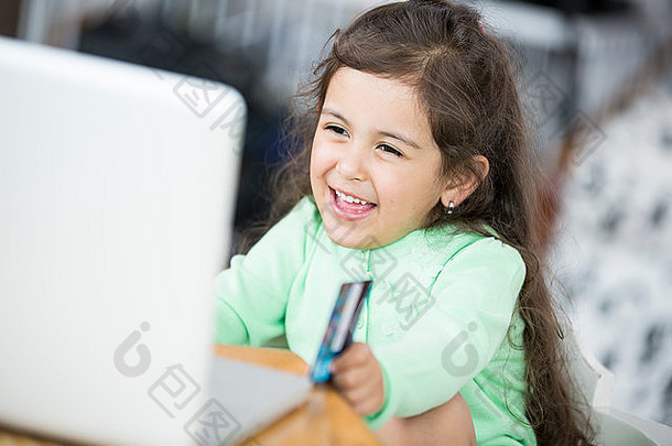 快乐女孩在家里用笔记本电脑和在线购物