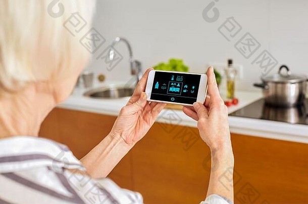 退休高级女人站控制聪明的首页智能手机回来视图特写镜头把光
