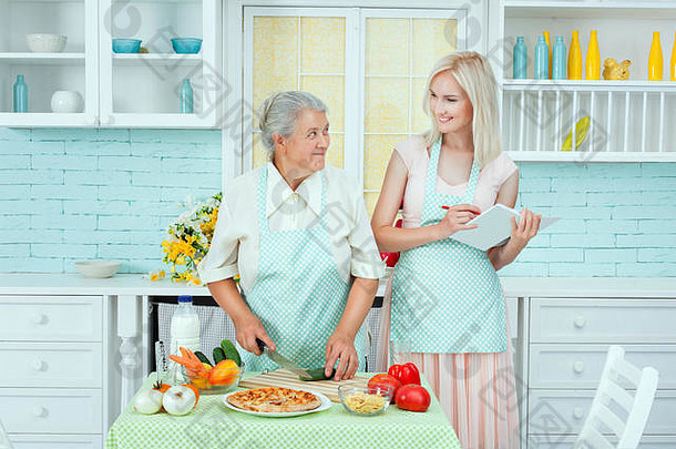 祖母告诉烹饪食谱年轻的女人学习烹饪厨房